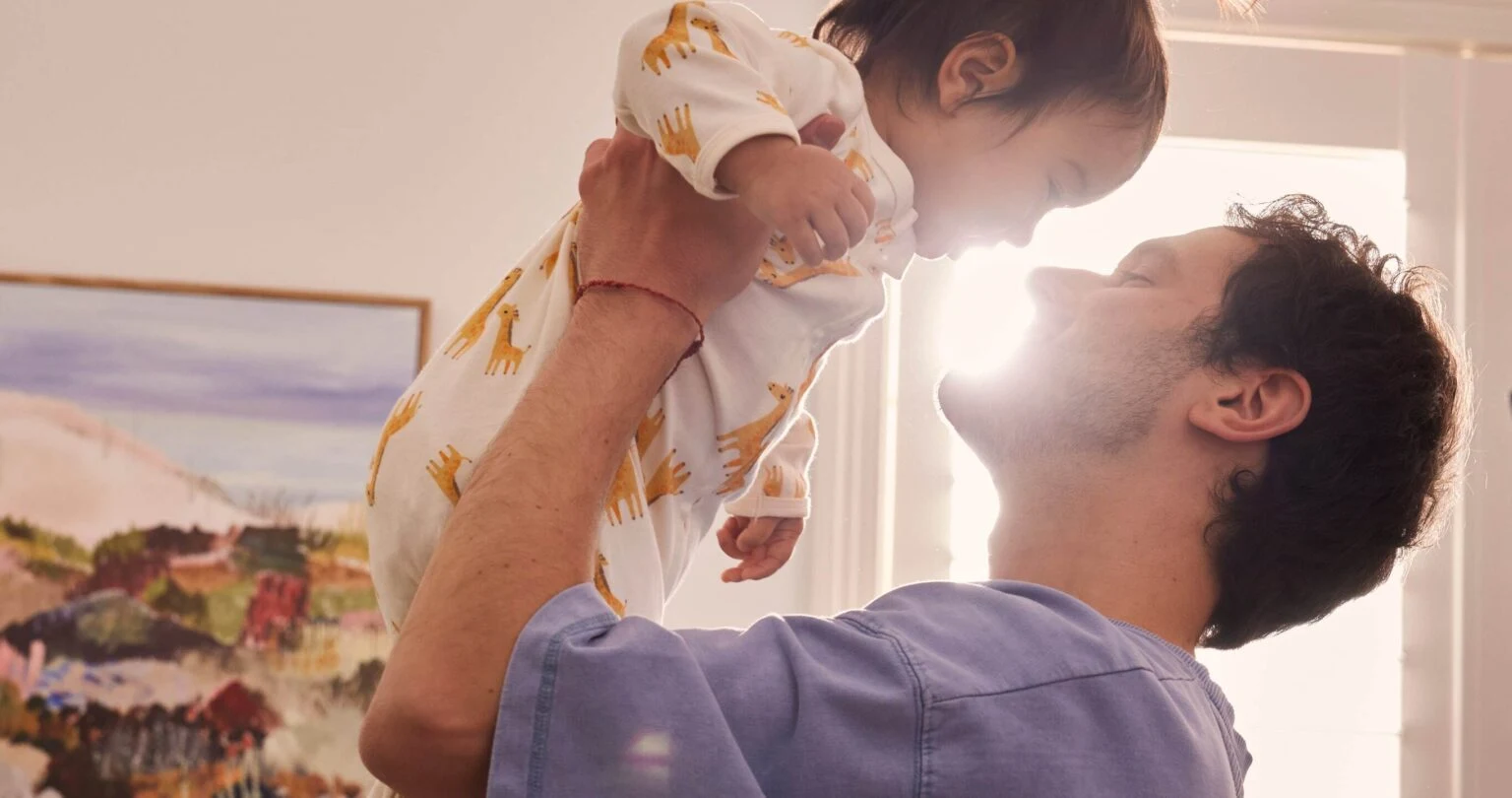 A father lifting his smiling baby